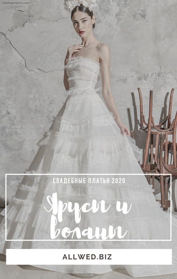 Длинное пышное свадебное платья Fiona от мастеров Дома Zuhair Murad выполнено в А-силуэте. Белое плотное кружево сочетается с фатином и фактурной тканью средней плотности, что придает образу четкости, уверенности. Юбка с многоярусными оборками отделена от облегающего лифа тонким условным поясом. Коллекция 2020